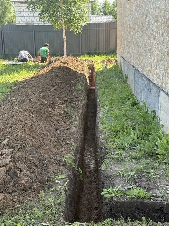 Траншея под водопровод вдоль стены дома
